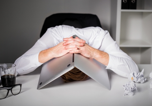 Man hiding under laptop