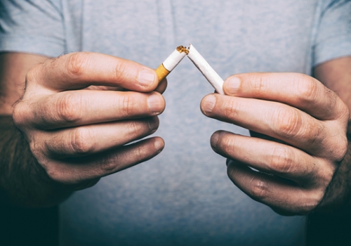 Quitting smoking - male hand crushing cigarette